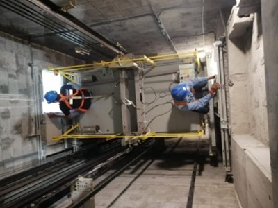Two technicians working in the elevator shaft