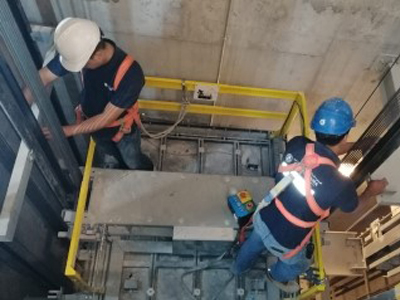 Two technicians working in the elevator shaft